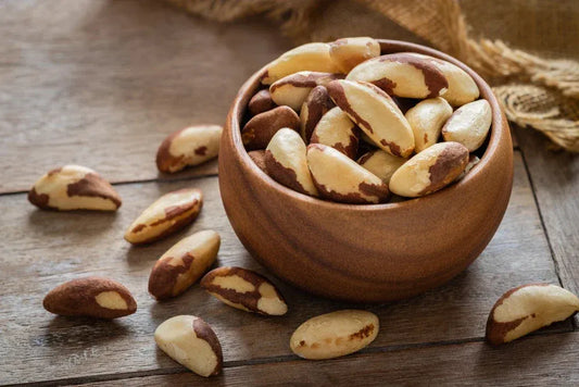 Wooden bowl filled with Brazil nuts on rustic table, highlighting their role in selenium intake and overall men’s health.