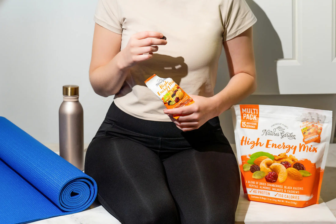 Woman enjoying Nature’s Garden High Energy Mix after a workout, with yoga mat and water bottle—perfect protein snack for recovery