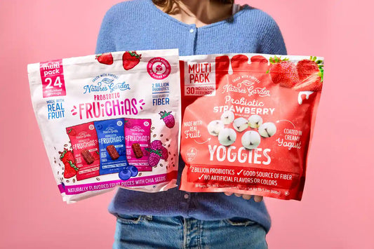 Woman holding Nature’s Garden Probiotic Fruichias and Yoggies snacks made with real fruit, fiber, and 2 billion probiotics per pack.