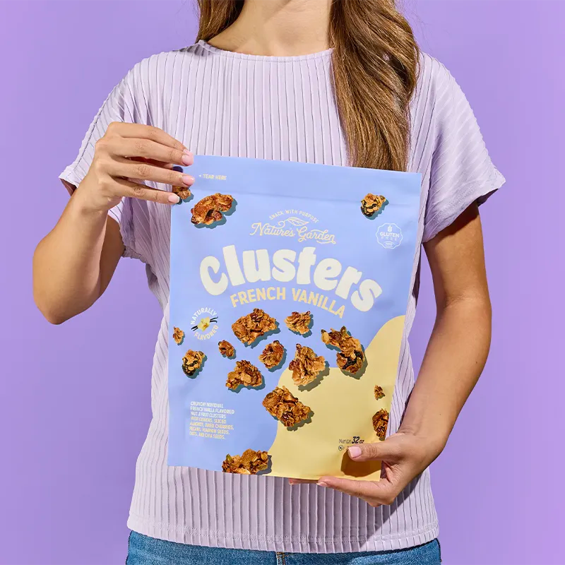 Person holding Nature’s Garden French Vanilla Clusters bag – better-for-you granola snack made with nuts, seeds, and vanilla flavor