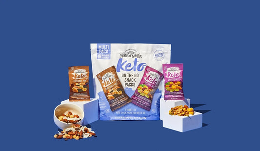Nature’s Garden Keto On-the-Go Snack Packs with 18 individual bags of Choconut Mix and Deluxe Mix displayed with nuts and seeds.