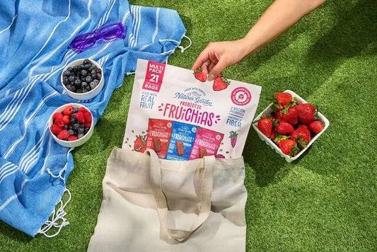 Nature's Garden Probiotic FruiChias fruit snacks with fresh berries at an outdoor picnic.
