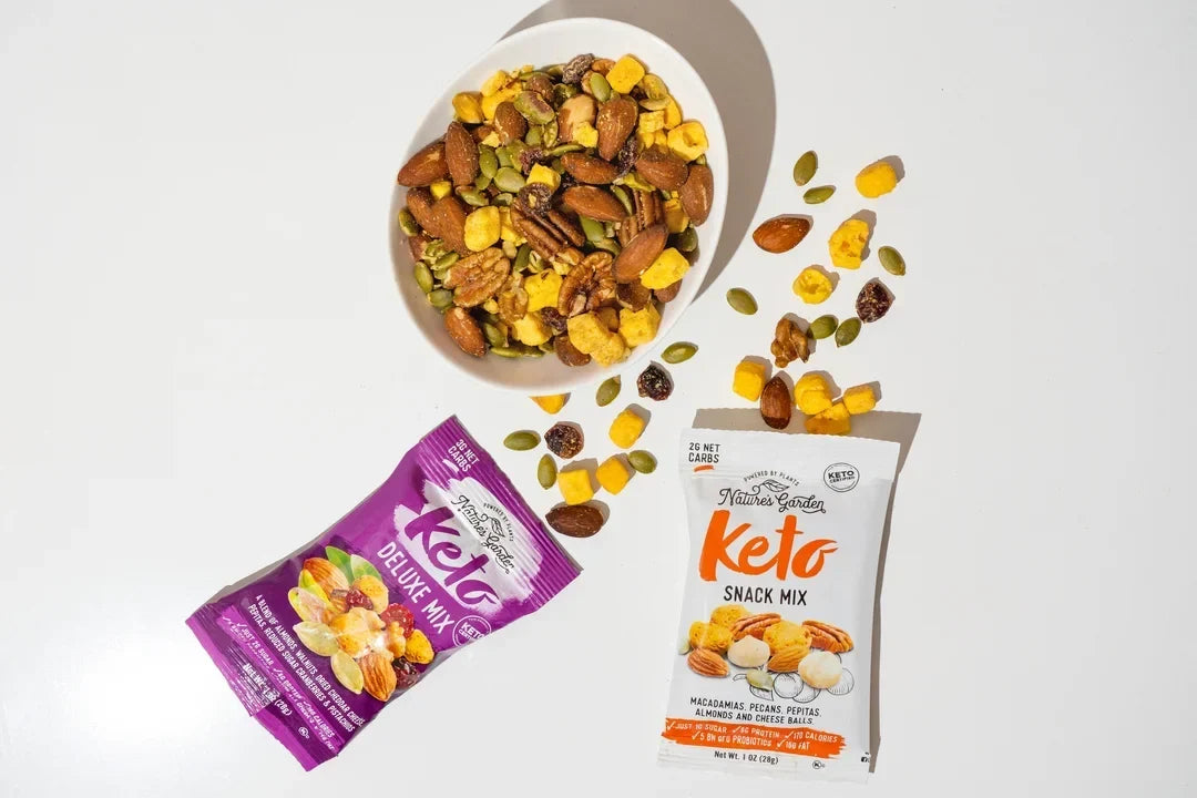 Nature’s Garden Keto Snack Mix and Keto Deluxe Mix with almonds, pecans, pepitas, cheese balls and dried fruit on white background