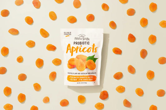 Bag of Nature’s Garden Probiotic Apricots surrounded by evenly spaced dried apricots on a cream background.