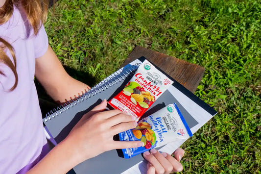 Nature’s Garden organic trail mix with dried fruit and nuts, seasonal fruit and nut pairing snack outdoors.