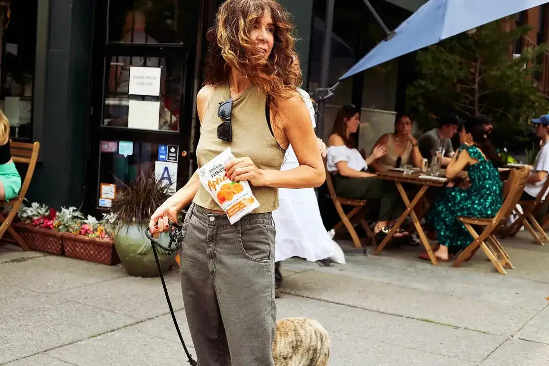 Woman enjoying Nature’s Garden Probiotic Apricots while out on a walk, showcasing on-the-go healthy snacking lifestyle.