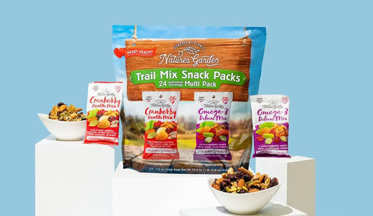 Nature’s Garden Trail Mix Snack Packs 24-count variety with Cranberry Health Mix and Omega-3 Deluxe Mix displayed with bowls of trail mix.